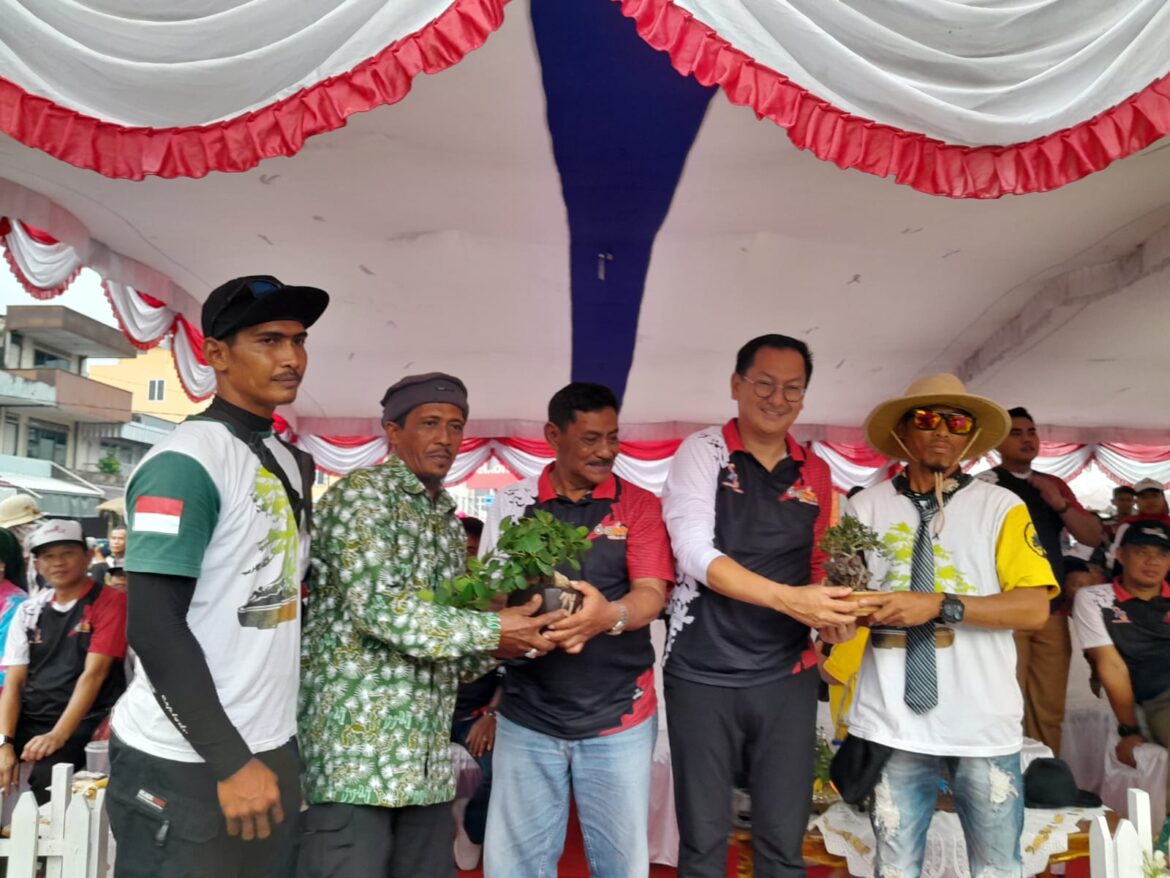 PAWAI PEMBANGUNAN, PPBI Kabupaten Belitung Serahkan Cendera Mata Berupa Bonsai Kepada Bupati Di Panggung Kehormatan