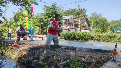 Warga Siram Jalan, Wujud Kepedulian Tuntasnya Sasaran Fisik TMMD 121 Mojokerto